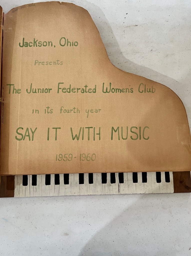 The inside cover of the Junior Federated Women's Club scrapbook from 1959-1960.  The theme that year was say it with music.